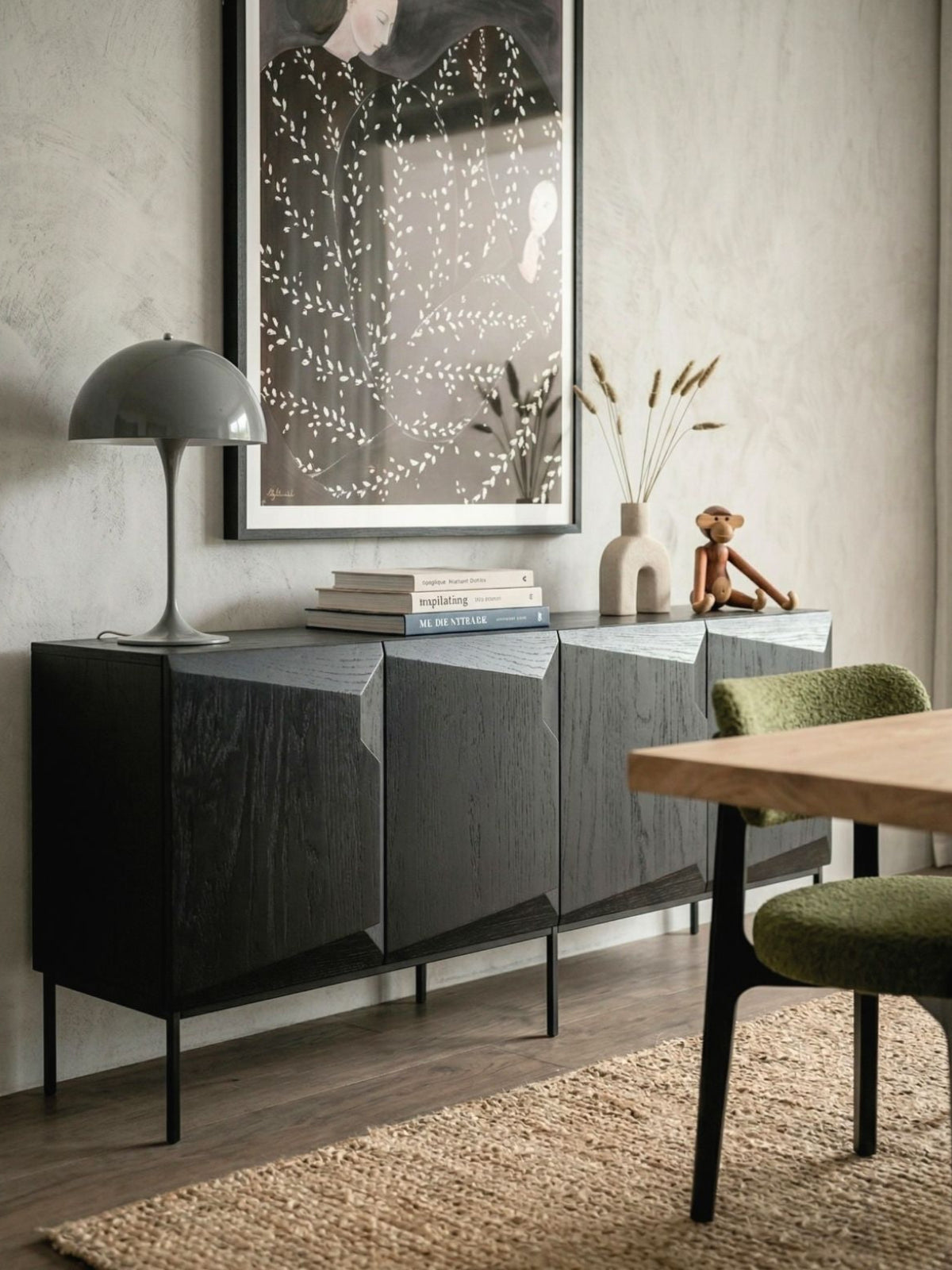 Modern interior with a black sideboard, wooden table, and decorative items.